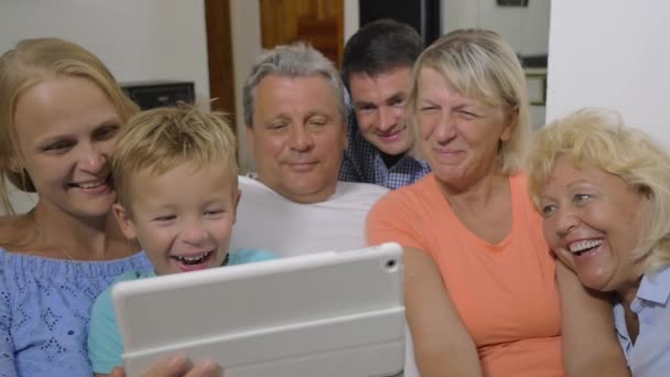 Familia con niño viendo interesante vídeo en la almohadilla — Vídeos de Stock