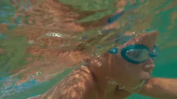 Dappere kleine jongen onderwater zwemmen — Stockvideo