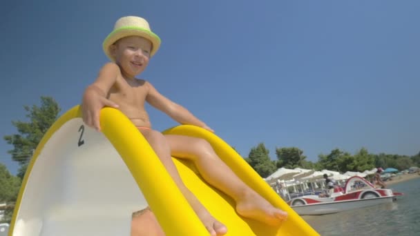 Child riding on slider at seaside — Stock Video