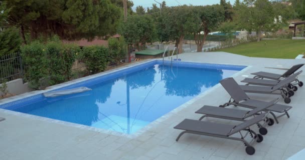 Outdoor pool with empty chaise longues — Stock Video