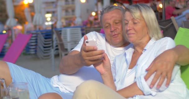 Couple sitting and looking at phone — Stock Video