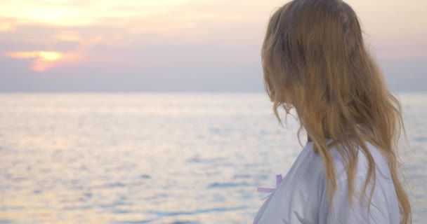 Kvinna med rosa awareness ribbon vid havet — Stockvideo