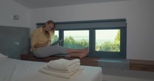 Женщина с блокнотом у окна в отеле — стоковое видео