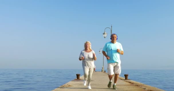 Pareja mayor corriendo por la mañana con música — Vídeos de Stock