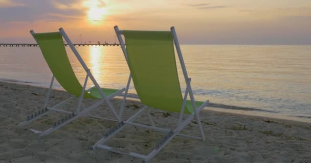 Chaise longues a la orilla del mar al atardecer — Vídeos de Stock