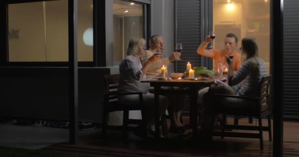 Nahaufnahme der Familie beim Gläserklirren und Abendessen — Stockvideo