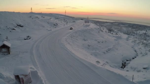 Vista aérea del coche conduciendo por carretera nevada y a la deriva — Vídeos de Stock