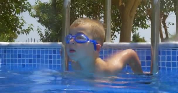 Garoto sorridente em óculos na piscina — Vídeo de Stock