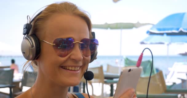 Frau im Headset-Videochat auf Handy — Stockvideo