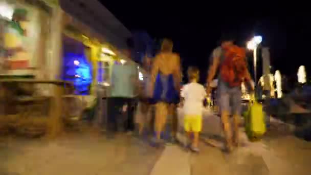 Hyperlapse of family walking along street at night — Stock Video