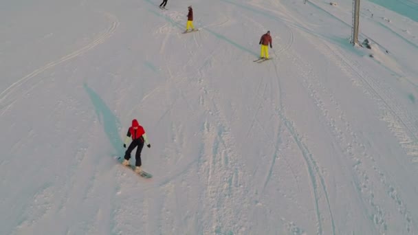 Vista aérea de esquiadores y snowboarders — Vídeos de Stock