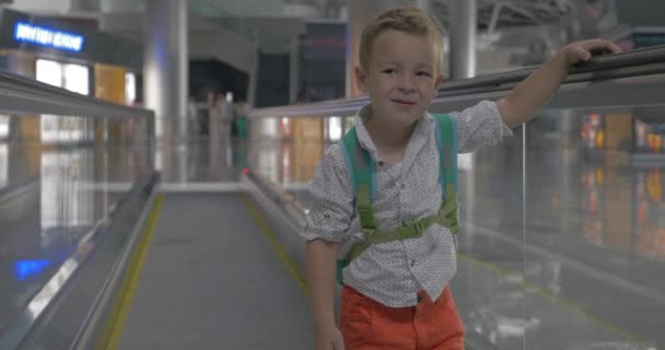 Schattige kleine jongen op roltrap in luchthaven — Stockvideo