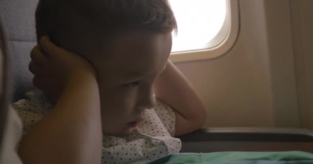 Kind hält im Flugzeug die Ohren zu — Stockvideo