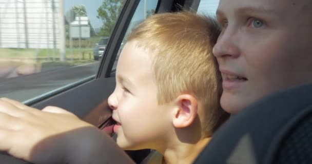 Mor och son tittar ut bil fönstret — Stockvideo