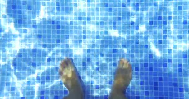 Male feet in clear water of the pool — Stock Video