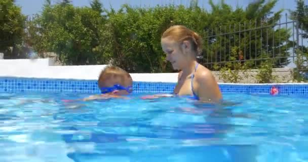 Mulher, menino e bola na piscina — Vídeo de Stock