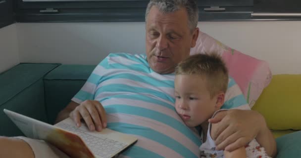 Enfant et grand-père utilisant un ordinateur portable à la maison — Video