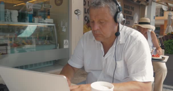 Man in Headphones Typing in Laptop — Stock Video