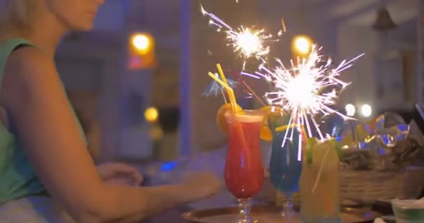 Cocktail glazen met wonderkaarsen serveren in hen — Stockvideo