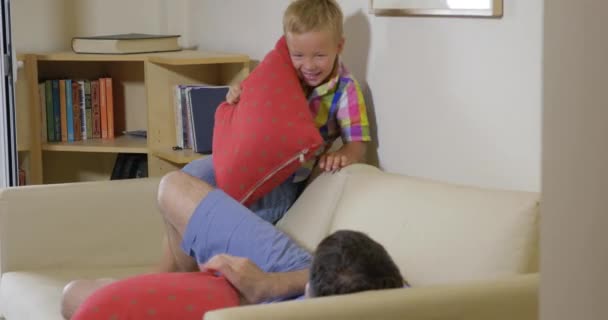 Hijo y papá peleando con almohadas en casa — Vídeos de Stock