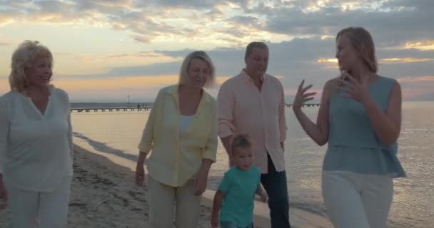 Velká rodina, sedící u stolu na pláži — Stock video