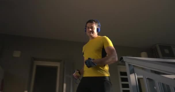 Adam kulaklık ve otel bırakarak spor giyim — Stok video