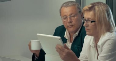 Tablet, kahve içme adam kullanan kadın