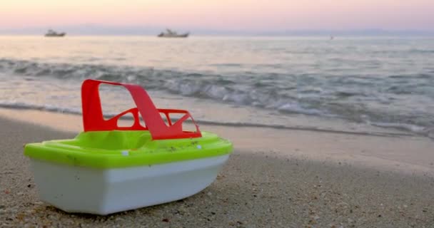 Plastic speelgoed schip door de zee golven — Stockvideo