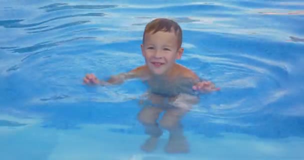 Garoto sorridente na piscina — Vídeo de Stock