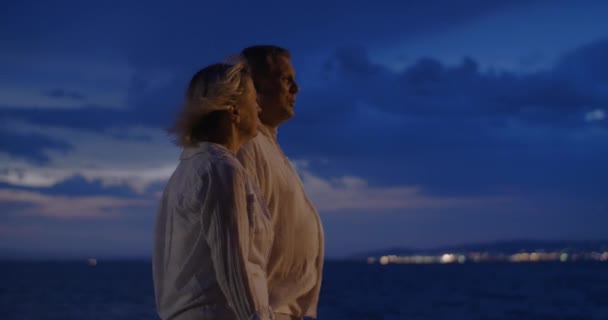 Personnes âgées se promenant le long de la mer la nuit — Video
