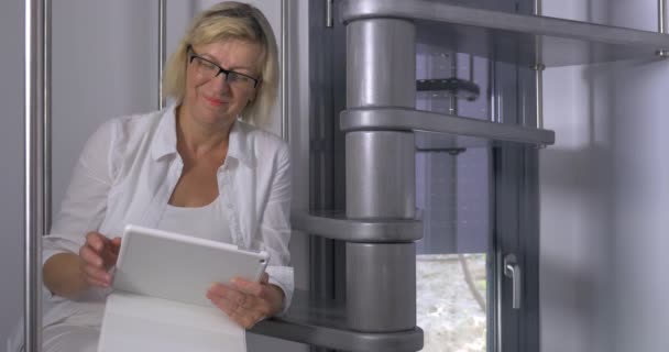 Erwachsene Frau sitzt mit Tablet auf Treppe — Stockvideo