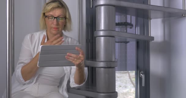 Reife Frau in Brille mit Tablette — Stockvideo