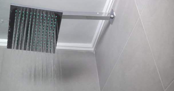 Água quente que flui da cabeça de chuveiro quadrada — Vídeo de Stock