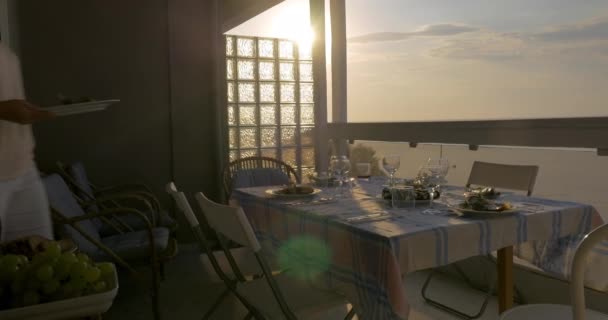 Woman serving dinner on the home balcony — Stock Video