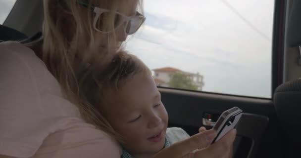 Μητέρα και γιος χρήση κινητού τηλεφώνου κατά τη διάρκεια το αυτοκίνητο βόλτα — Αρχείο Βίντεο