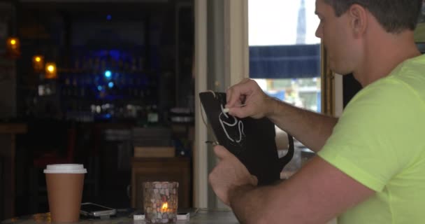 Man in café tekening koffie lijst met krijt — Stockvideo