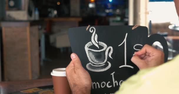 男人写在黑板上的咖啡价格 — 图库视频影像