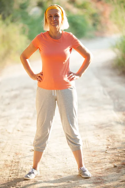 Mature Woman Standing with Hands on Hips on Road — Stock Photo, Image