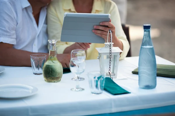 Couple d'âge moyen utilisant une tablette à la table — Photo