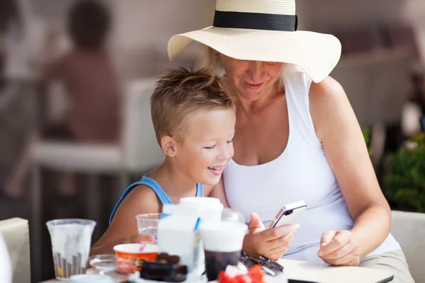 Mormor och barnbarn använder mobiltelefon tillsammans — Stockfoto