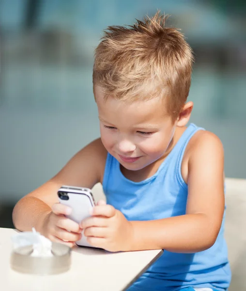 Retrato de un niño rubio usando un teléfono celular —  Fotos de Stock