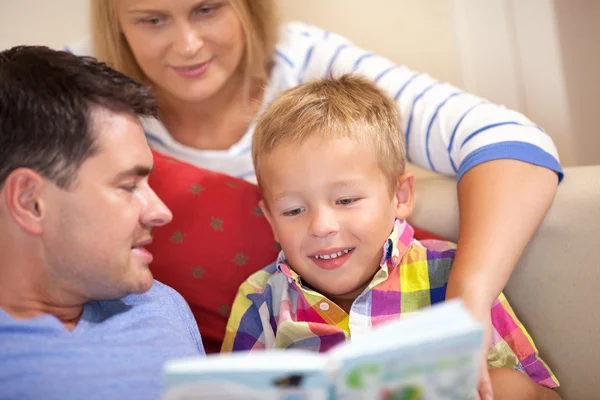 Young family reading a book together — Stock Photo, Image