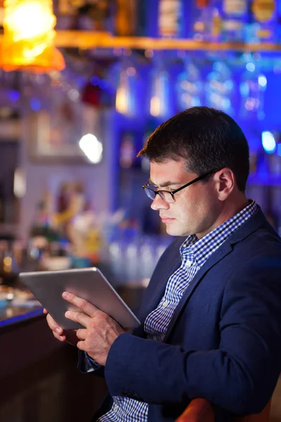 Homme d'affaires lisant une tablette dans un bar à cocktails — Photo