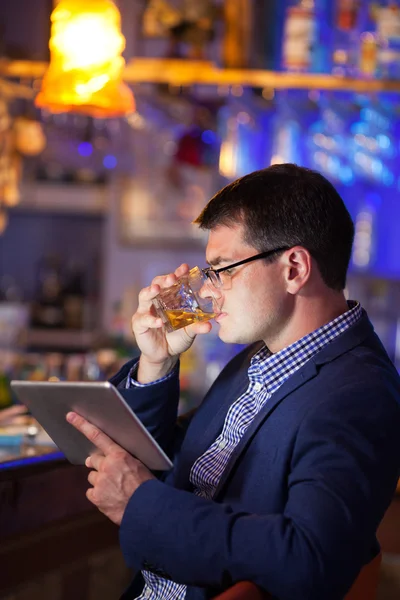 Businessman enjoying a drink at a club — Stock Photo, Image