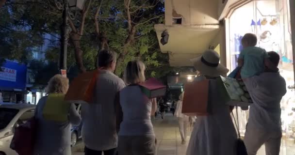 Gran familia caminando por la calle nocturna después de ir de compras — Vídeo de stock