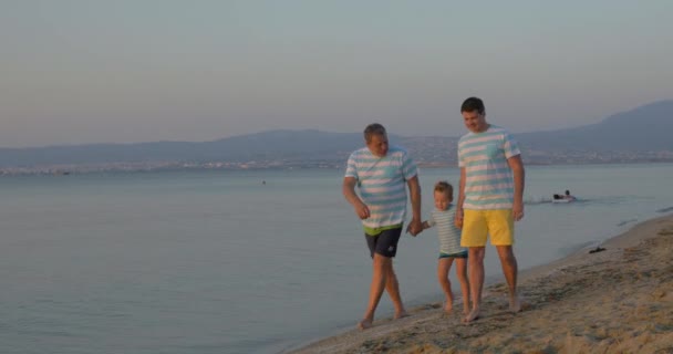 Niño, padre y abuelo caminando por la playa — Vídeo de stock