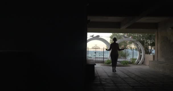 Woman in headphones skipping rope in the yard — Stock Video