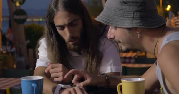 Dos amigos usando smartwatch en el café de la calle — Vídeos de Stock