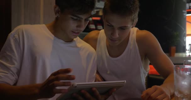 Dos amigos adolescentes con Tablet PC en la cafetería — Vídeo de stock