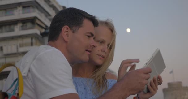 Couple with pad on sea-front in the evening — Stock Video